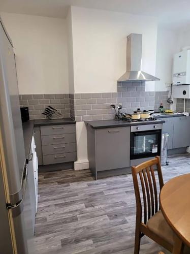 a kitchen with a stove and a table in it at Double Bed A Burnley City Centre in Burnley