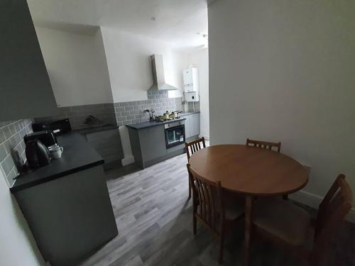 a kitchen with a wooden table and a table and chairs at Double Bed A Burnley City Centre in Burnley
