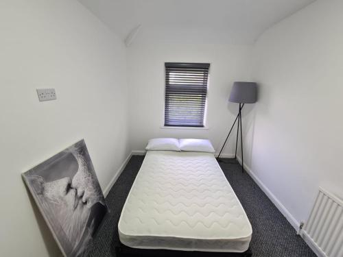 a small bedroom with a mattress in a room with a window at Emergency - Bedrooms Only in Birkenhead