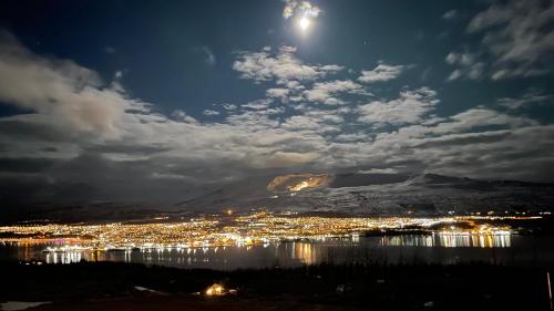 a view of a city at night with the moon at Eys Cabin in Akureyri