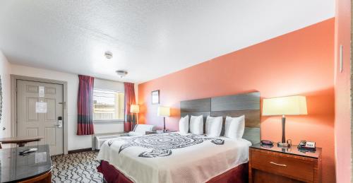 a hotel room with a bed with an orange wall at Motel 6 Galveston, TX Seawall in Galveston