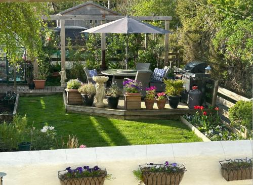 a garden with potted plants and an umbrella at Castle View in Lochaline