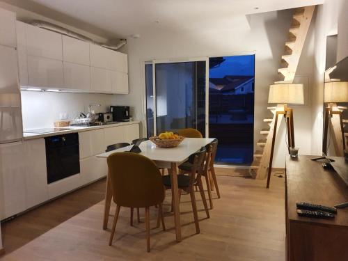 une cuisine et une salle à manger avec une table et des chaises dans l'établissement Appartement sur Terrasse, à Capbreton