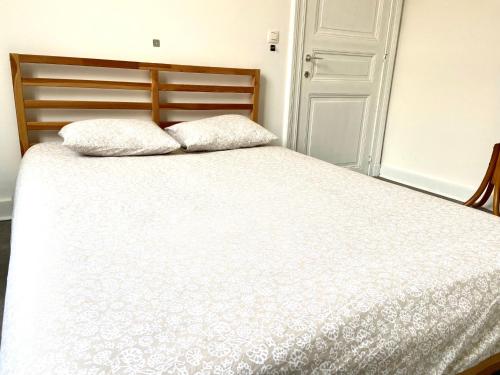 a bed with two pillows on top of it at Au logement mosan in Namur