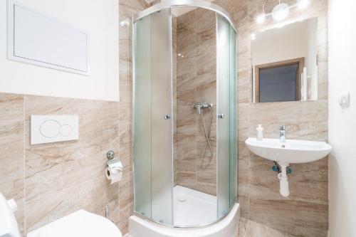 uma casa de banho com um chuveiro e um lavatório. em Brand new studio apartment #51 with free secure parking in the center em Praga