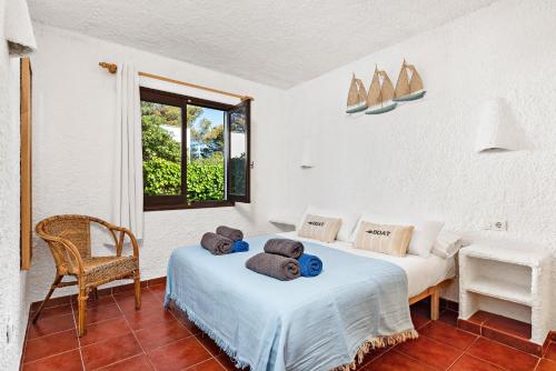 1 Schlafzimmer mit 2 Betten und einem Fenster in der Unterkunft Apartamentos Menorca MONSINES 13C By Mauter Villas in Cala Blanca