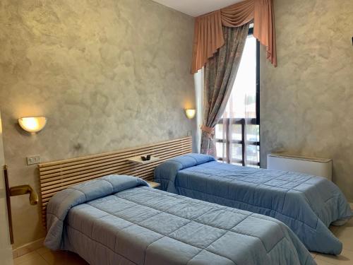 una camera con due letti e una finestra di River Park Hotel ad Ameglia