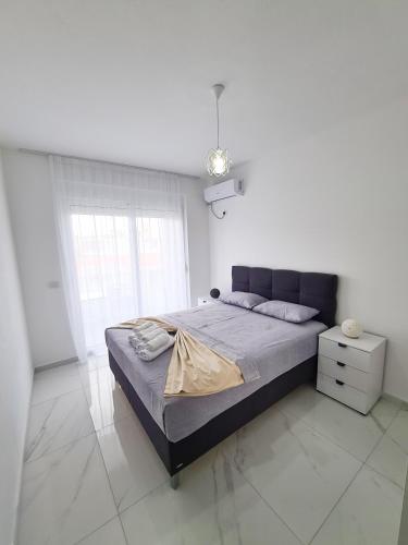 a bedroom with a large bed in a white room at Apartments Amar in Ulcinj
