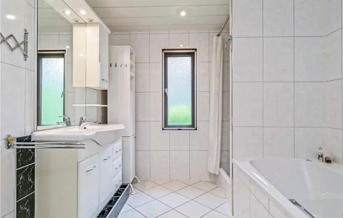 La salle de bains blanche est pourvue d'une baignoire, d'un lavabo et d'une baignoire. dans l'établissement 2 Bedroom Amazing stacaravan In Markelo, à Markelo