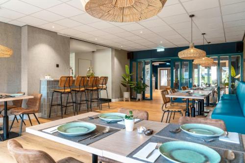 a dining room with tables and chairs in a restaurant at Hotel de Gentsche Poort in Biervliet