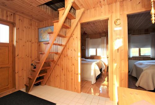 a room with two beds and a wooden staircase at Eys Cabin in Akureyri