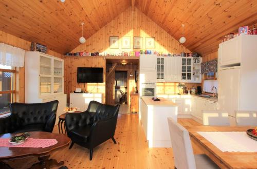 a kitchen with white cabinets and a wooden ceiling at Eys Cabin in Akureyri