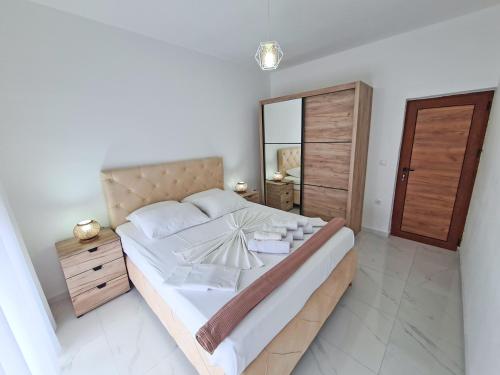 a bedroom with a large bed and a mirror at Apartments Amar in Ulcinj