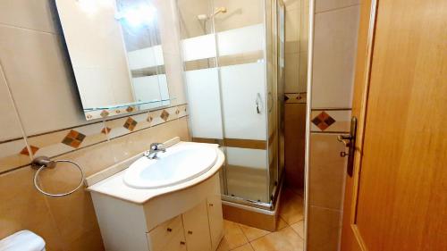 une salle de bain avec lavabo et douche dans l'établissement Quarteira Beach Vacation: 2BR steps to the sand, à Quarteira