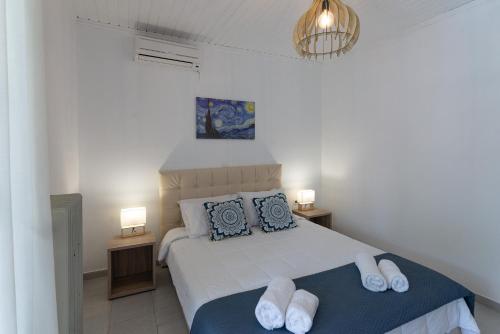 1 dormitorio con 1 cama con 2 almohadas y 2 lámparas en Zografia, en Corfú