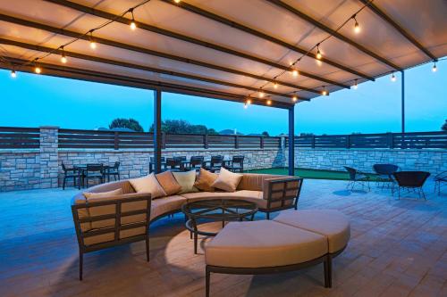 a patio with a couch and a table and chairs at Courtyard Dallas Grand Prairie in Grand Prairie
