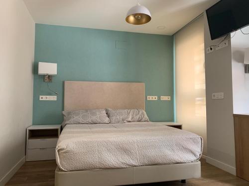 ein Schlafzimmer mit einem Bett und einer blauen Wand in der Unterkunft Joyel de la Ribera in Aranda de Duero