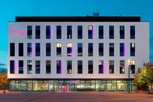 un grand bâtiment blanc avec des fenêtres roses et noires dans l'établissement Moxy Ludwigshafen, à Ludwigshafen