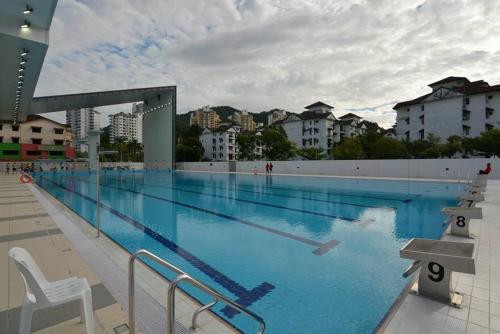 a large swimming pool with blue water at Cozy AC Shared Bunk Beds in Bayan Lepas in Bayan Lepas