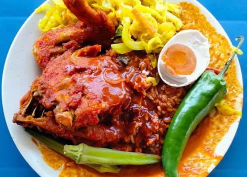 un plato de comida con chile y verduras en una mesa en Cozy AC Shared Bunk Beds in Bayan Lepas en Bayan Lepas