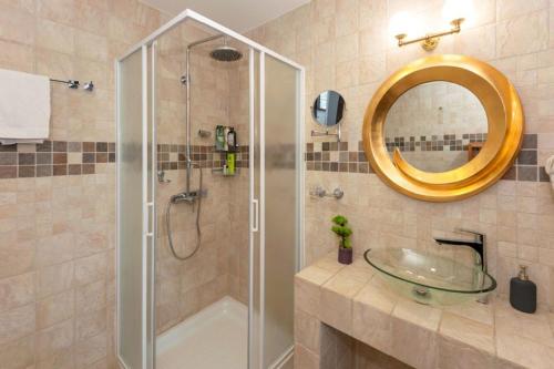 ein Bad mit einer Dusche, einem Waschbecken und einem Spiegel in der Unterkunft Cape Serenity Mansion in Ayia Napa