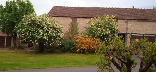 ein Haus mit blühenden Bäumen vor einem Hof in der Unterkunft APPARTEMENT INDEPENDANT DANS MAISON PARTICULIERE in Bayet