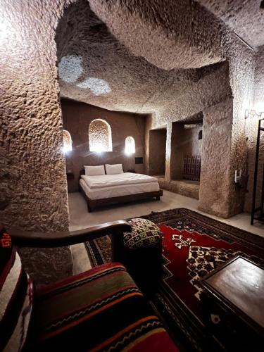 a room with a bed and a couch in a stone room at Grand Uchisar Hotel in Uchisar