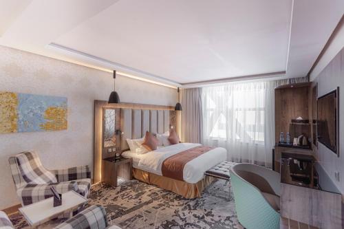 メディナにあるGacine Hotel Al Tahliaのベッドとリビングルームが備わるホテルルームです。