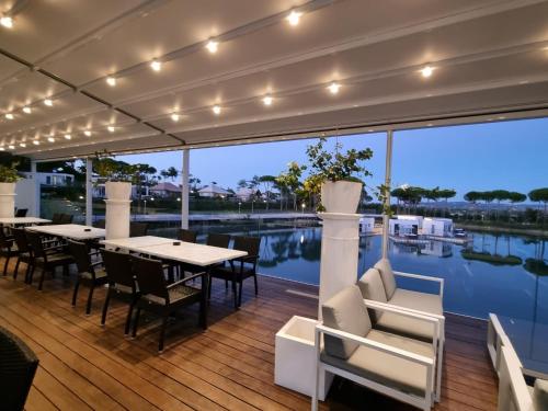 a deck with tables and chairs and a view of the water at Villaggio La Pescaccia in San Clemente