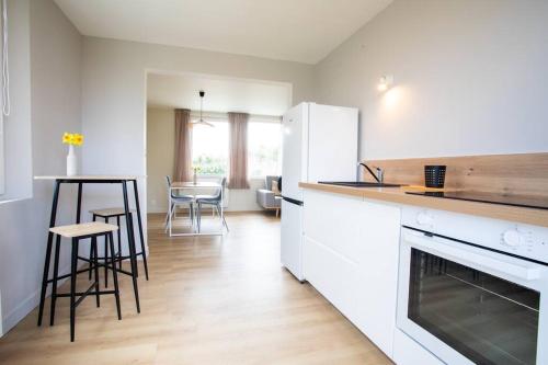 uma cozinha com electrodomésticos brancos e uma mesa e cadeiras em Les Pipelettes en Baie em Pendé