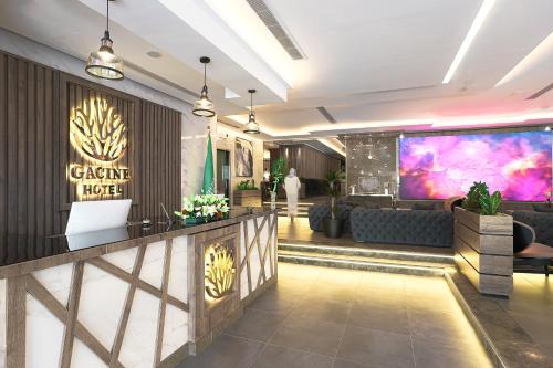 a lobby of a hotel with a large screen at Gacine Hotel Tahlia فندق غسن التحلية in Al Madinah