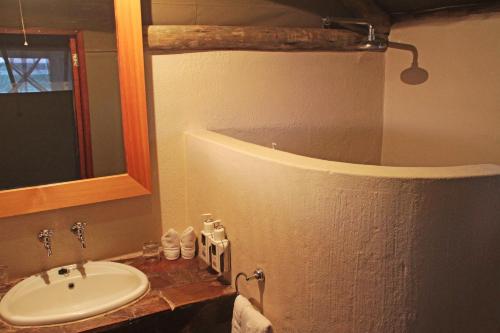 a bathroom with a sink and a mirror at Suricate Tented Kalahari Lodge in Hoachanas