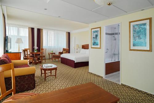 a hotel room with a bed and a living room at Leipzig Marriott Hotel in Leipzig