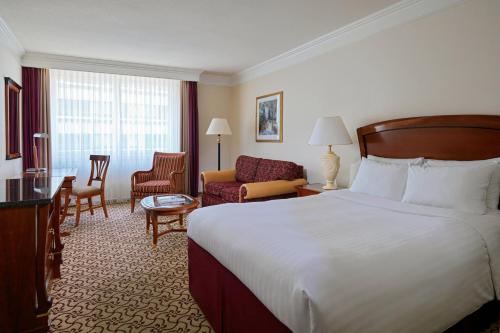 ライプツィヒにあるライプツィヒ マリオット ホテルのベッドとリビングルームが備わるホテルルームです。
