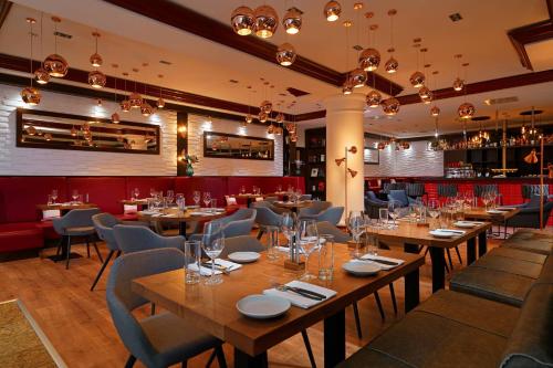 a dining room with wooden tables and chairs at Leipzig Marriott Hotel in Leipzig
