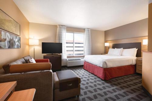 une chambre d'hôtel avec un lit et un canapé dans l'établissement TownePlace Suites by Marriott Denver Downtown, à Denver