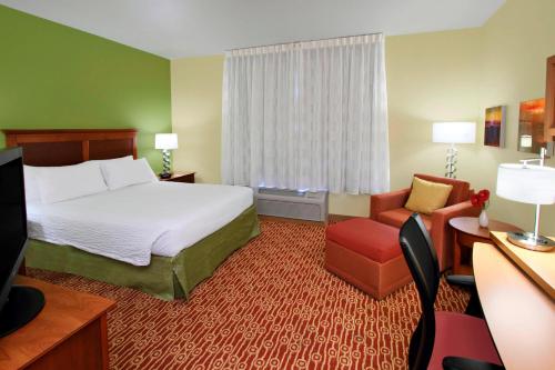 a hotel room with a bed and a chair at TownePlace Suites San Jose Campbell in Campbell