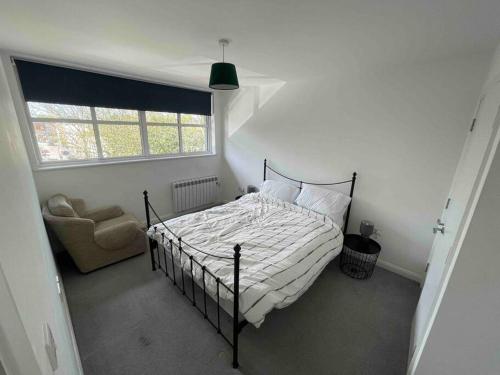 a bedroom with a bed and a chair and a window at 2 Bed city centre flat in Bath