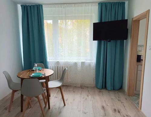 a dining room with blue curtains and a table and chairs at Mewa86 in Gdynia