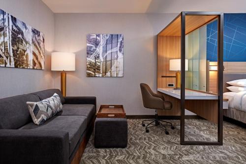 a hotel room with a couch and a desk and a bed at SpringHill Suites by Marriott Los Angeles Downey in Downey