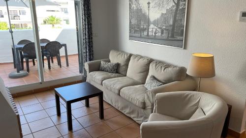 sala de estar con sofá, silla y mesa en Hacienda Golf Islantilla, en Islantilla