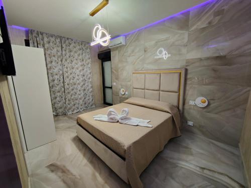 a bedroom with a bed with two white shoes on it at B&B MaisonAlysie in Foggia
