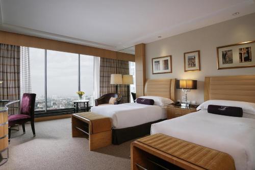 a hotel room with two beds and a large window at Lugal, A Luxury Collection Hotel in Ankara