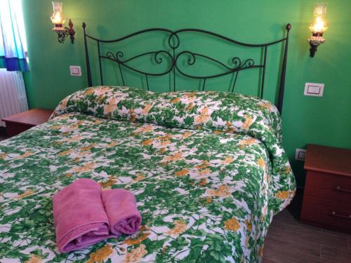 La Casa in Campagna في San Martino in Pensilis: سرير عليه منشفتين أرجوانيتين في غرفة النوم