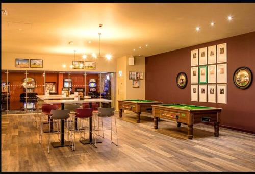 a room with two pool tables and a bar at Holiday home in Dymchurch - New Beach Holiday Park in Dymchurch