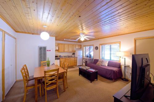 ein Wohnzimmer mit einem Tisch und einem Sofa sowie eine Küche in der Unterkunft Sitzmark Sports Lodge in Red River