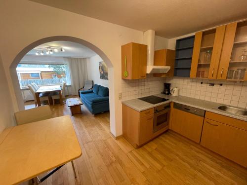 a kitchen and living room with a blue couch and a table at Ferienwohnung Maxi in Maishofen