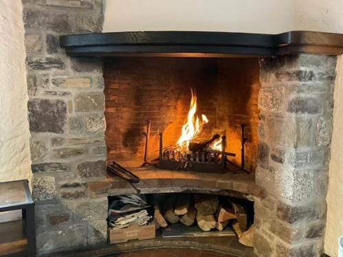 Una gran chimenea de ladrillo con fuego. en Chalet Airaudi, en Saint-Martin-Vésubie