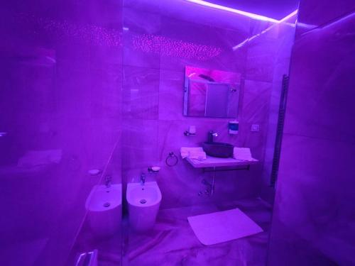 a purple bathroom with a sink and a toilet at B&B MaisonAlysie in Foggia