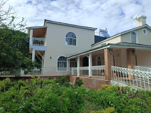 a large white house with a balcony on the side at Captains Villa - where Lake Malawi and Shire River meet, historical hotel at waterfront next to the Lake Museum in Mangochi Town in Mponda